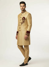 Load image into Gallery viewer, Man wearing a traditional beige sherwani with intricate patterns on a white background