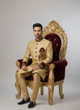 Load image into Gallery viewer, Man wearing a traditional beige sherwani with intricate patterns on a white background