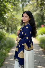 Load image into Gallery viewer, Woman in a blue and gold traditional outfit standing in a garden.