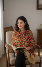 Load image into Gallery viewer, Woman sitting in a chair wearing a floral shawl, holding a book in a cozy room.