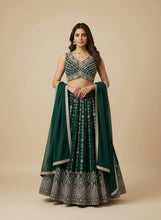 Load image into Gallery viewer, Woman wearing a traditional navy blue and silver lehenga on a beige background