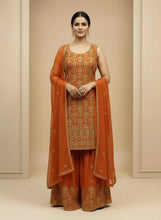 Load image into Gallery viewer, Woman wearing an orange traditional outfit with a matching dupatta against a beige background

