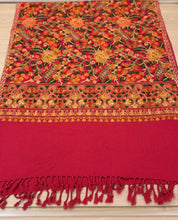 Load image into Gallery viewer, Red fabric with intricate floral patterns and fringes on a wooden surface

